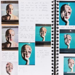 Close up of visual arts diary displaying photographs of a face for a body of work