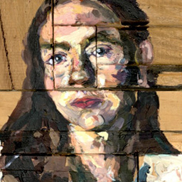 Close up detail of textured painted portrait of a woman in a blue shirt with long brown hair on wooden blocks.